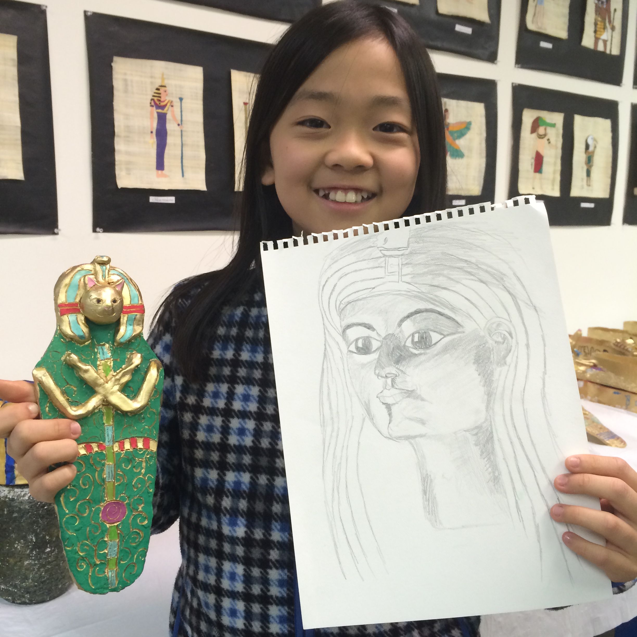 Young student painting top of volcano sculpture red.
